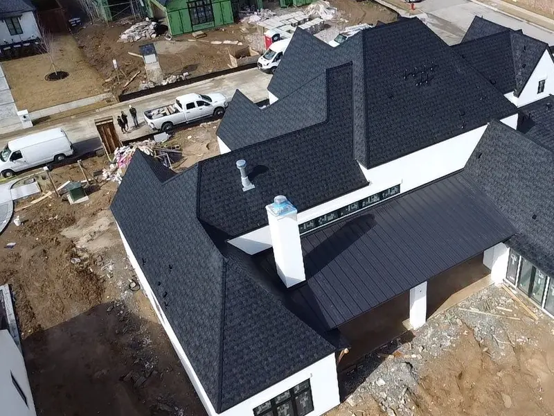 Aerial view of a modern white home with a Euroshield roof and standing seam porch