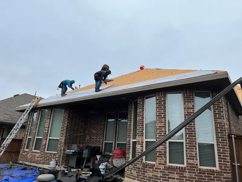 Crew installing new decking and underlayment on a brick home