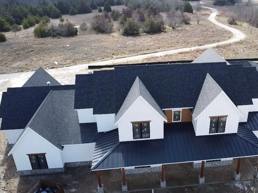 White farmhouse with a standing seam metal porch roof